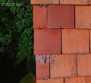 Exposed roof tile hangers and deteriorated roof tile surface (DJI_0012)